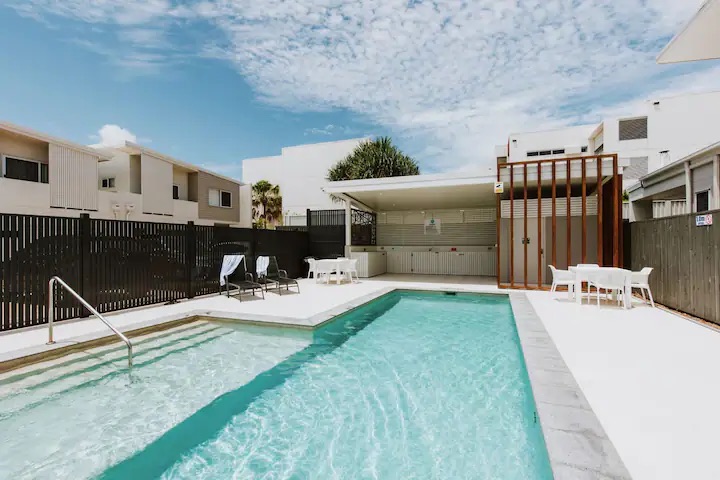 view of a shine social respite accommodation with a pool and loungers